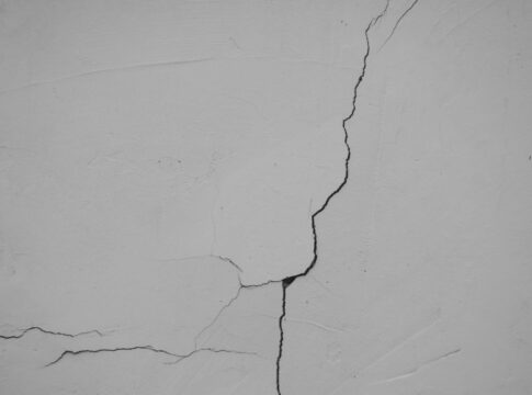 Fissure sur un mur enduit blanc