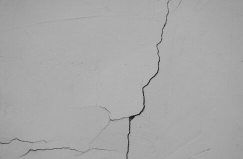 Fissure sur un mur enduit blanc
